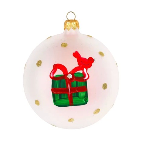 The Kitchen Table 2026 handpainted glass ornament featuring a red bird and green gift box on a white background.