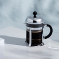 The Kitchen Table Bodum Chambord 4-cup French press coffee maker with glass carafe and polished chrome frame.