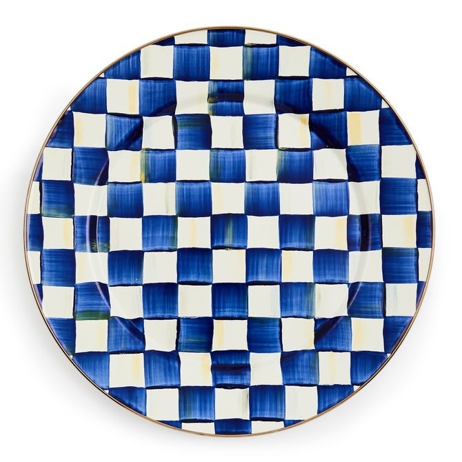 The Kitchen Table enamel dinner plate with a hand-painted blue and white checkered pattern and bronze-tone rim.