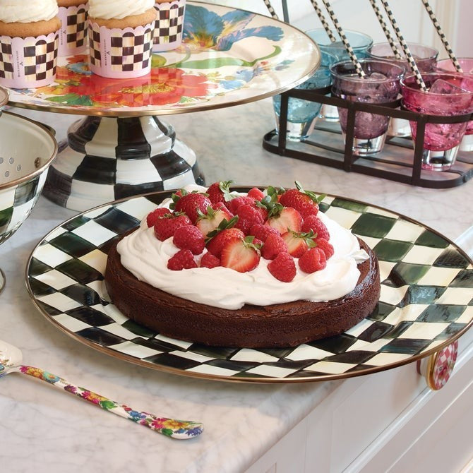 The Kitchen Table Courtly Check enamel dinner plate featuring a black and white pattern with a bronze-tone rim.