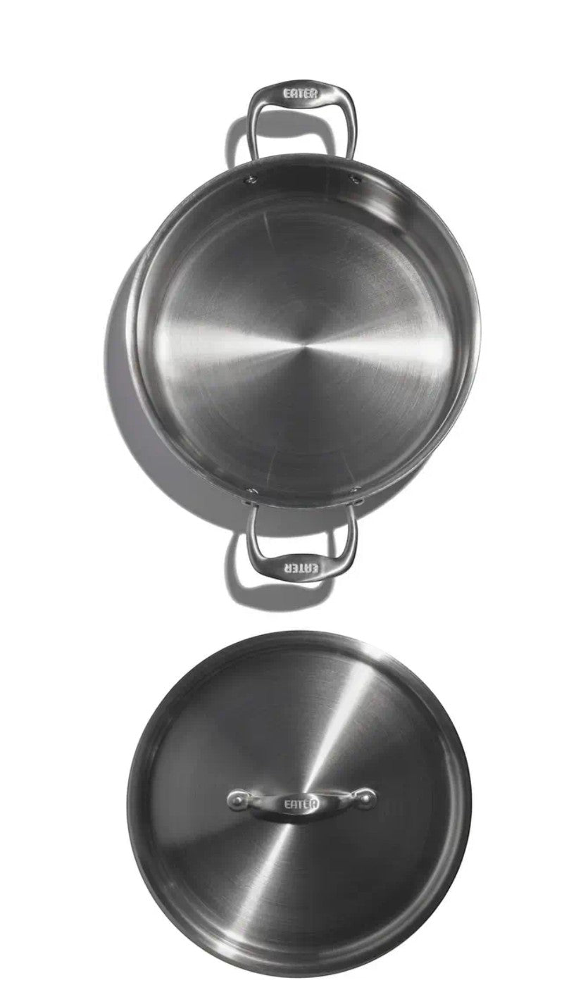 The Kitchen Table EATER 6 quart stainless steel rondeau pan with matching lid, shown from a top-down view.