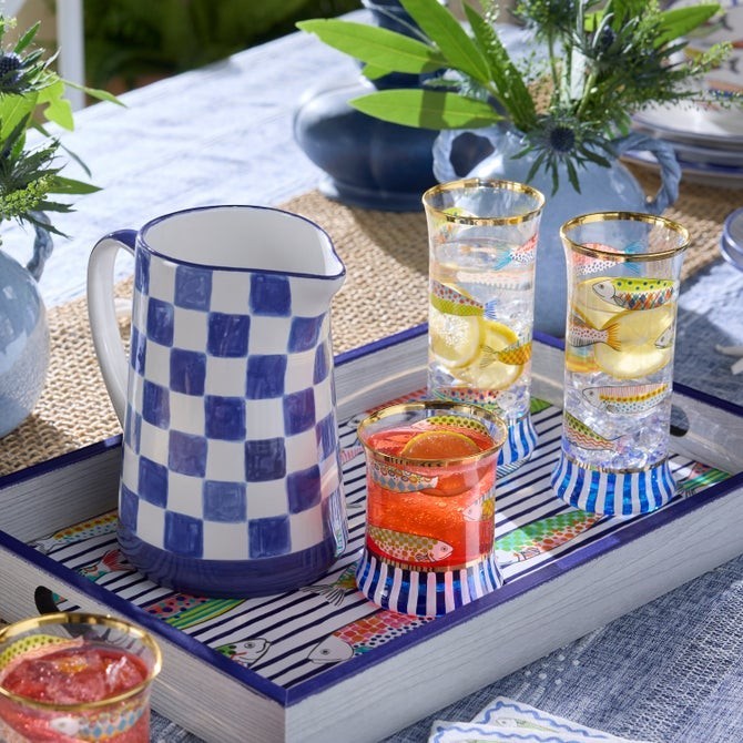 The Kitchen Table Go Fish highball glasses featuring hand-painted fish motifs, navy stripes, and gold lustre rims.