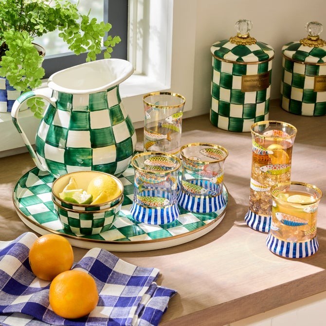 The Kitchen Table Go Fish tumbler glasses featuring hand-painted navy stripes, fish motifs, and gold lustre rims.