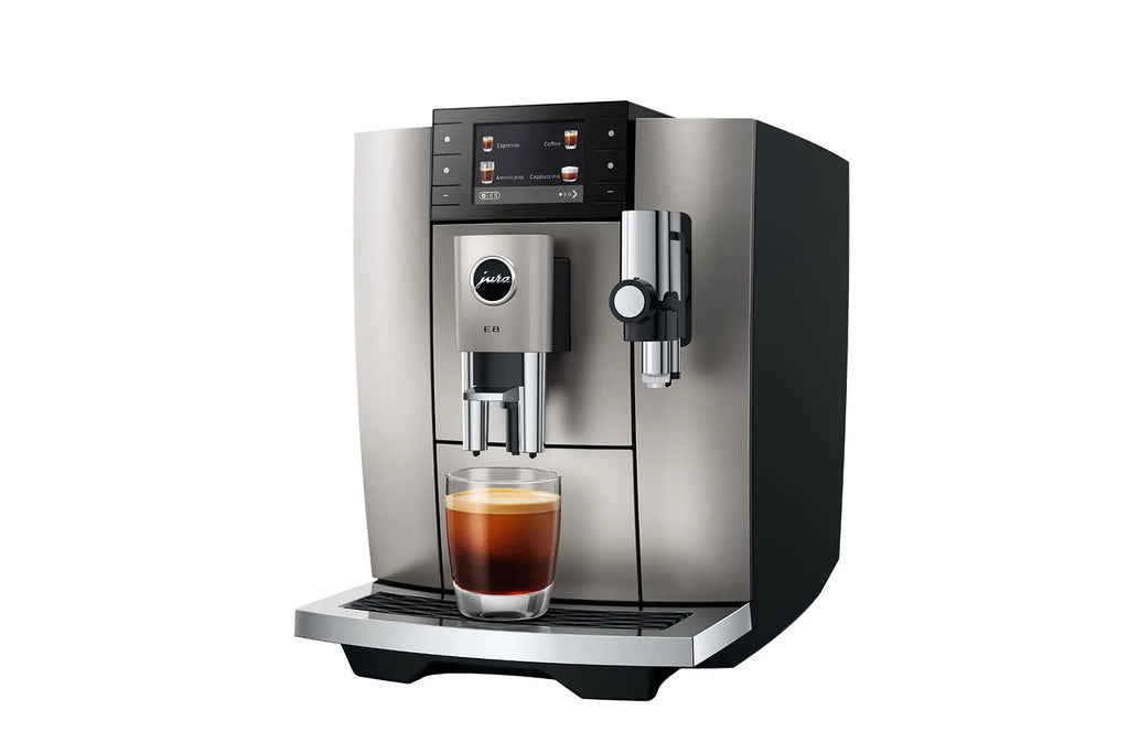 The Kitchen Table Jura E8 automatic coffee machine in midnight silver with a touchscreen display and glass of espresso