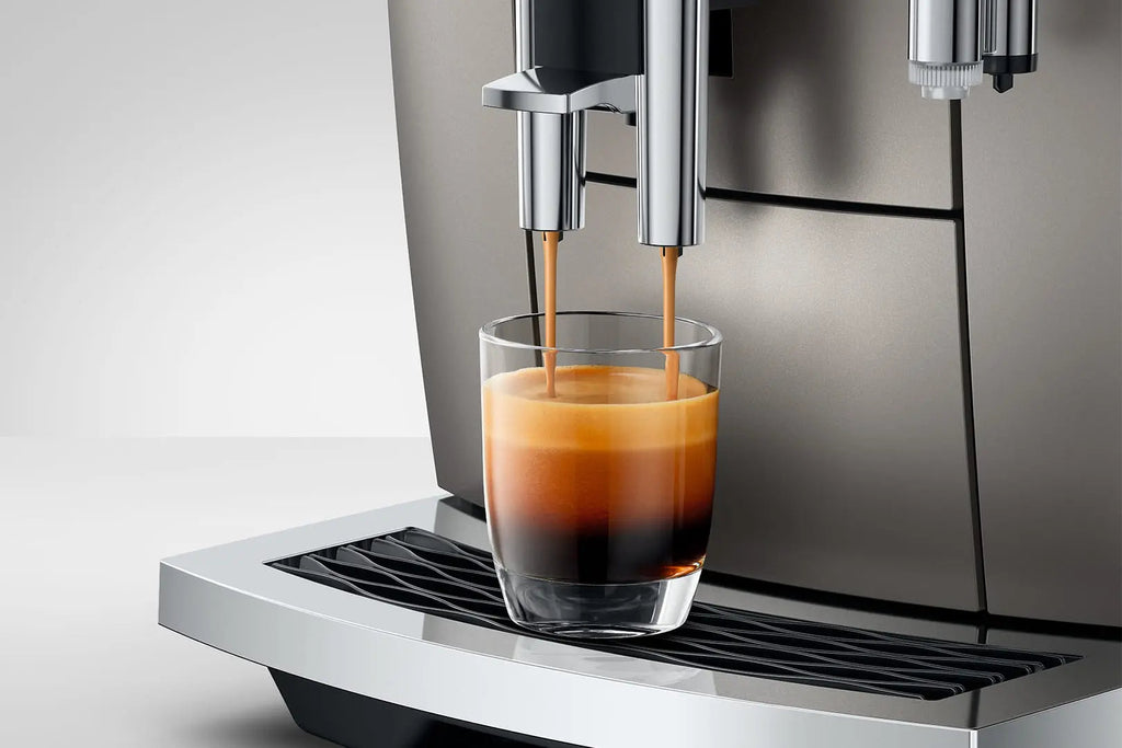 The Kitchen Table Jura E8 Midnight Silver coffee machine dispensing fresh espresso into a glass cup