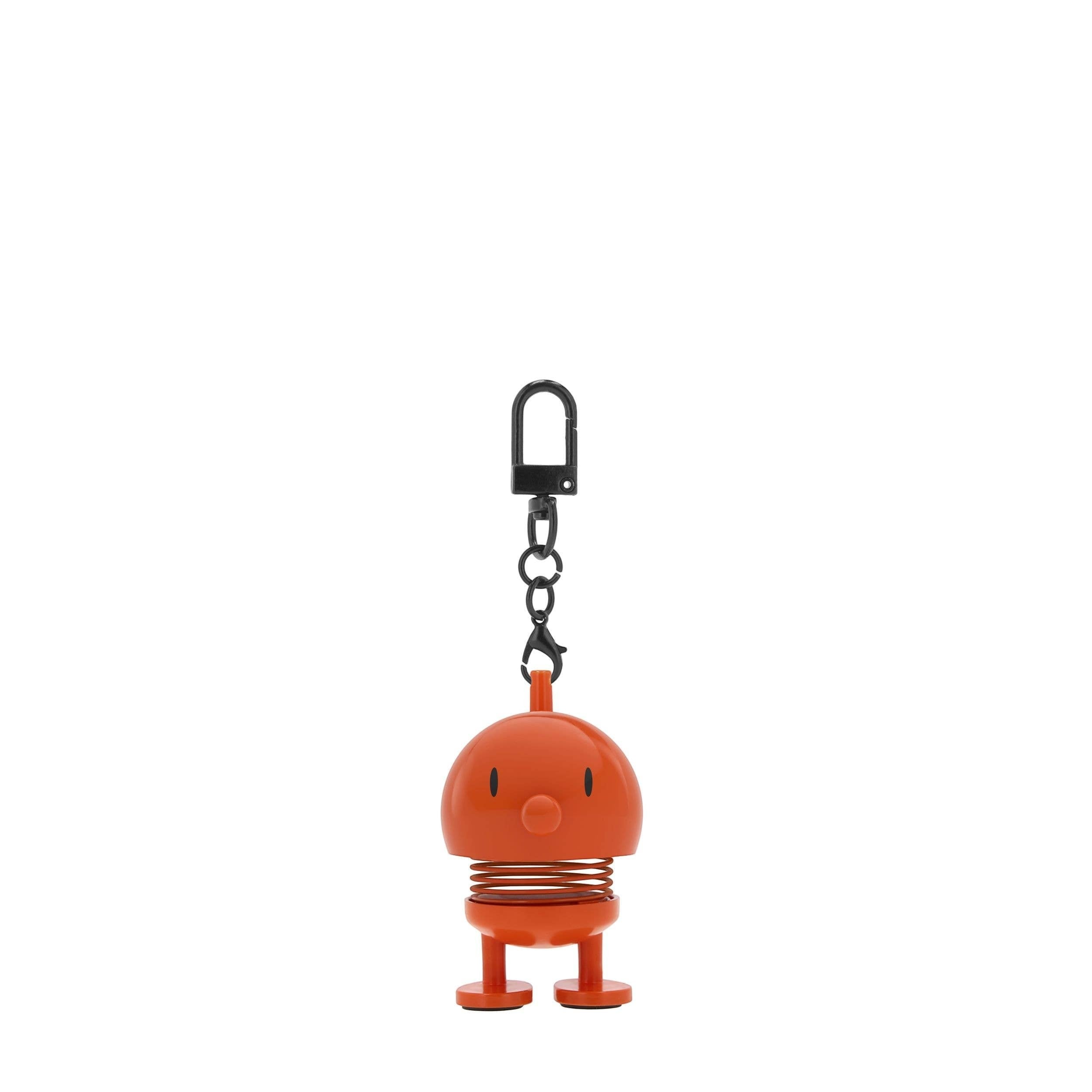 The Kitchen Table orange Hoptimist bag charm with a playful spring design and a black metal clip attachment.