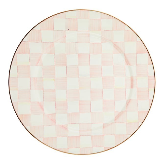 The Kitchen Table enamel dinner plate with a soft pink and white checkered pattern and a bronze-tone stainless rim.