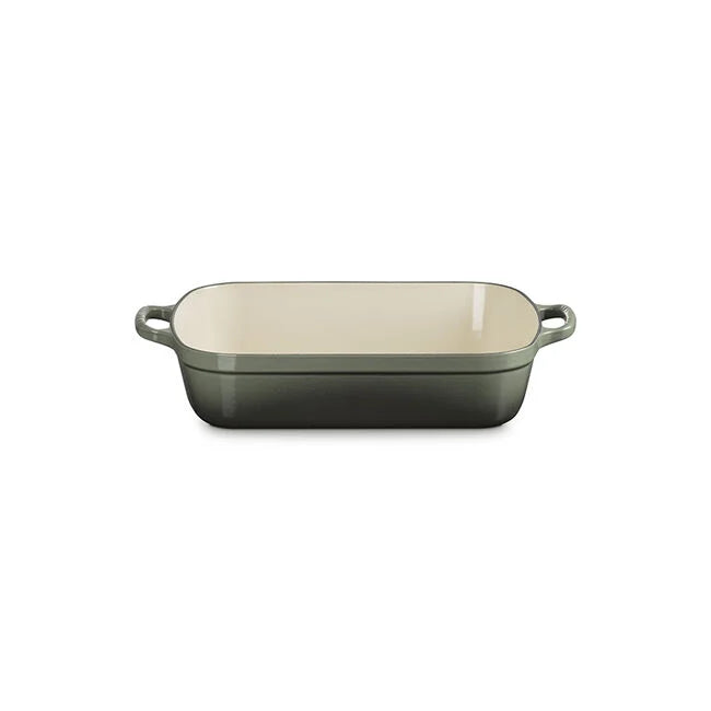 The Kitchen Table Signature rectangular enameled cast iron roaster in sage green with wide loop handles.