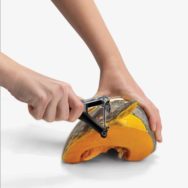 The Kitchen Table Sharple Y-Peeler with self-sharpening blade peeling a piece of pumpkin with ergonomic handle