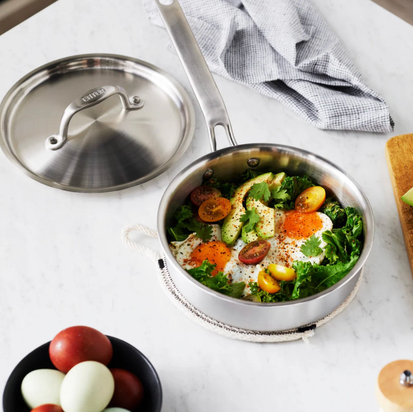 The Kitchen Table 1.5 quart stainless steel mini saute pan with lid filled with a breakfast dish of eggs and kale