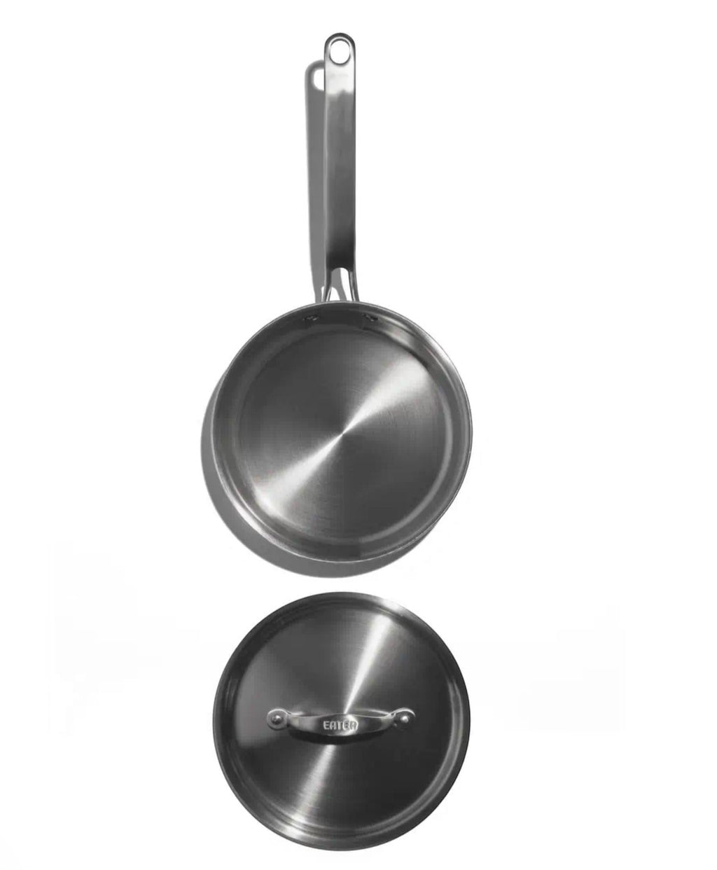 The Kitchen Table 1.5 quart stainless steel mini sauté pan with matching lid, top-down view on white background.