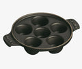 The Kitchen Table Staub cast iron escargot dish with six holes for cooking and serving snails.